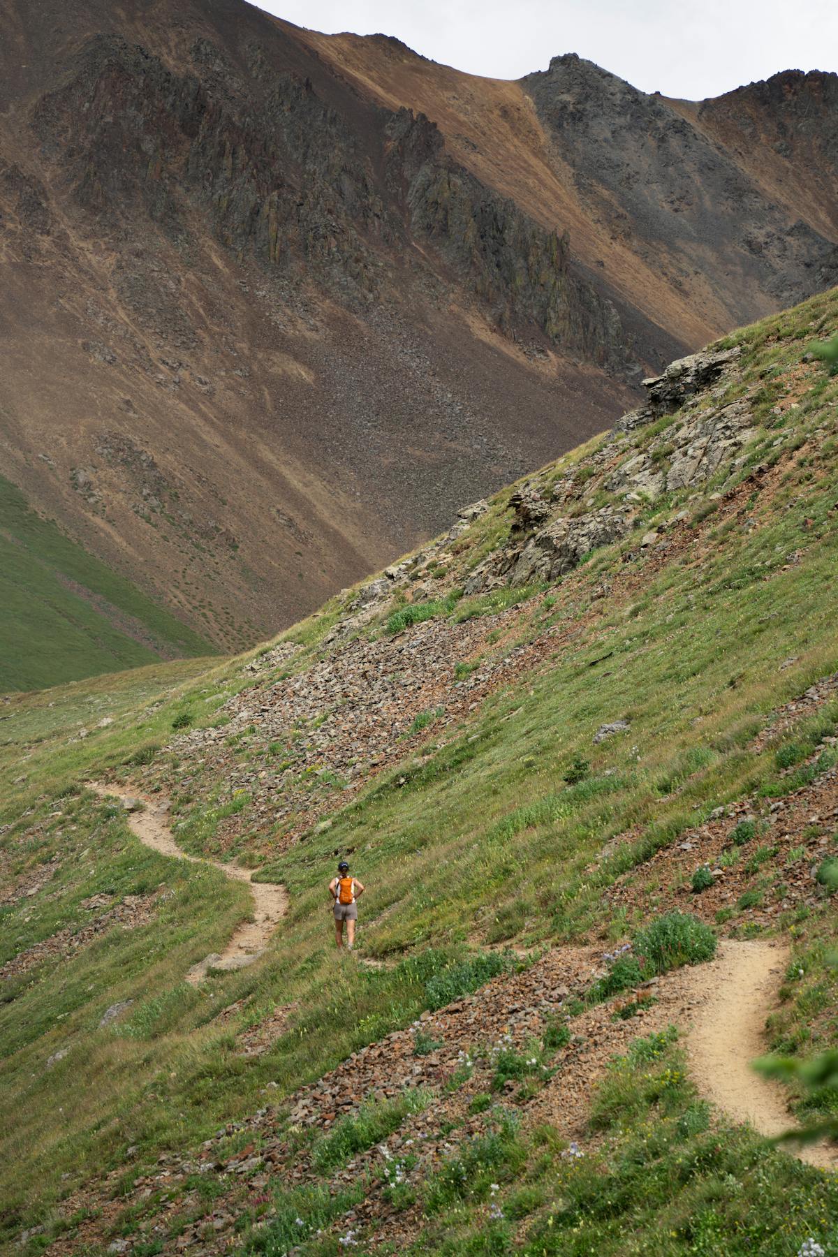 Hiker walking up a winding mountain trail.