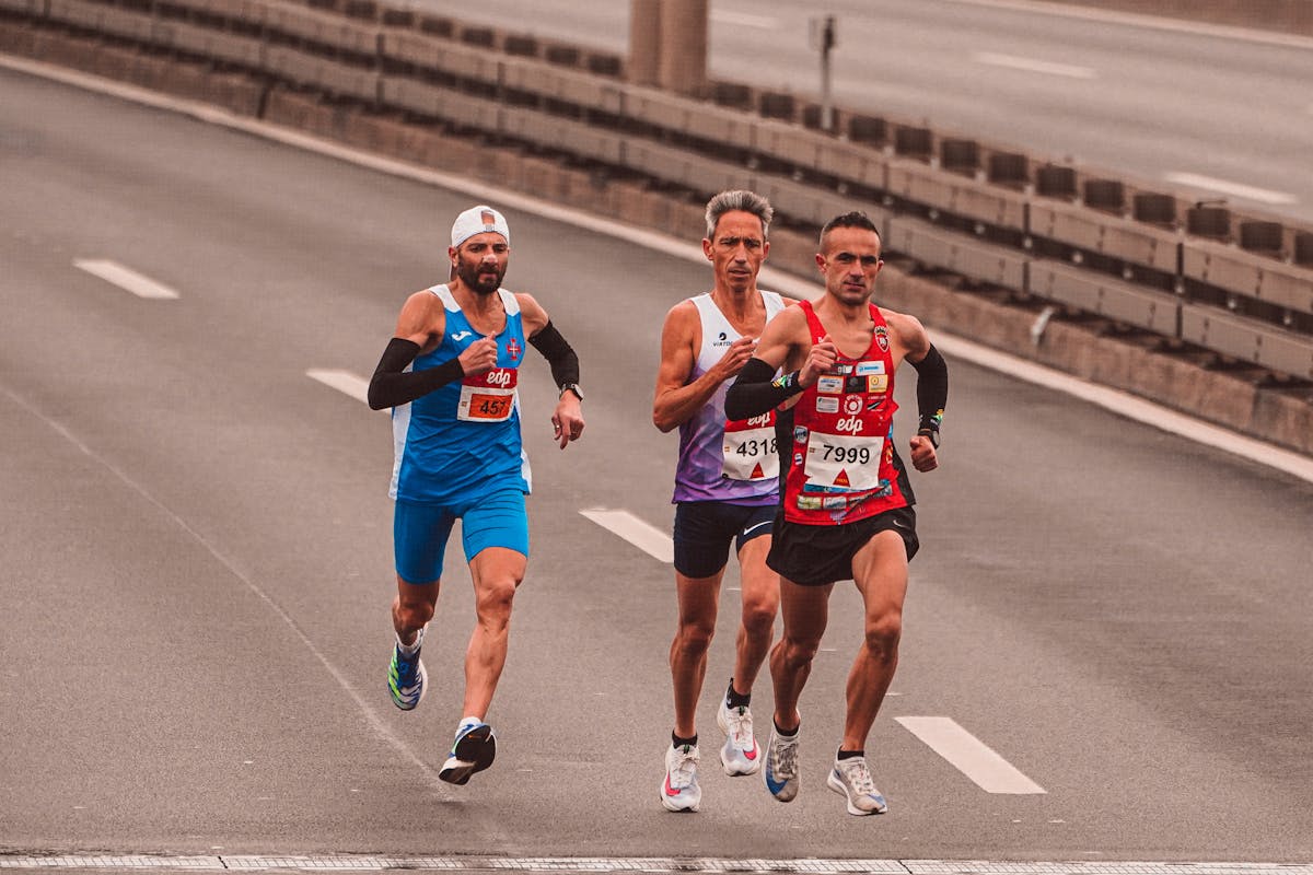Marathon runners moving down a city road.